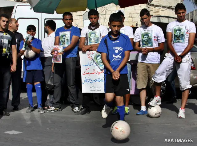 Palestinian protestors hold pictures of Palestinian prisoner Mahmoud Al-Sarsak, who is still refusing food for 92 days after a deal was made to end a mass prisoner hunger strike, during a demonstration in support him, in...