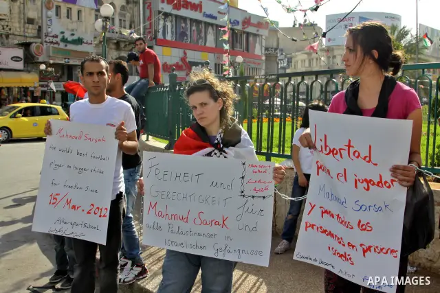 Palestinian protestors hold banners and pictures of Palestinian prisoner Mahmoud Al-Sarsak, who is still refusing food for 92 days after a deal was made to end a mass prisoner hunger strike, during a demonstration in sup...
