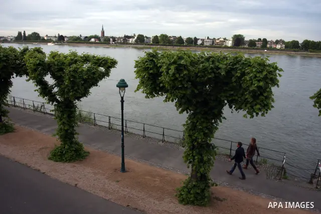 Germans walk near the river Rhine near the city of Bonn in Germany on 15 June 2012. The Rhine is one of the longest and most important rivers in Europe. It runs for over 1,232 km .Rhine flows through six countries -Switz...