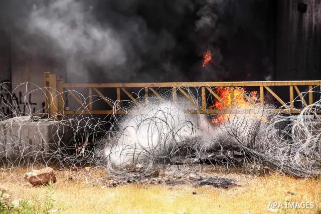Palestinian protesters burn tires during a weekly demonstration against Israel's controversial separation barrier in the West Bank village of Nilin on June 15, 2012. When completed, 85 percent of the wall will have been...