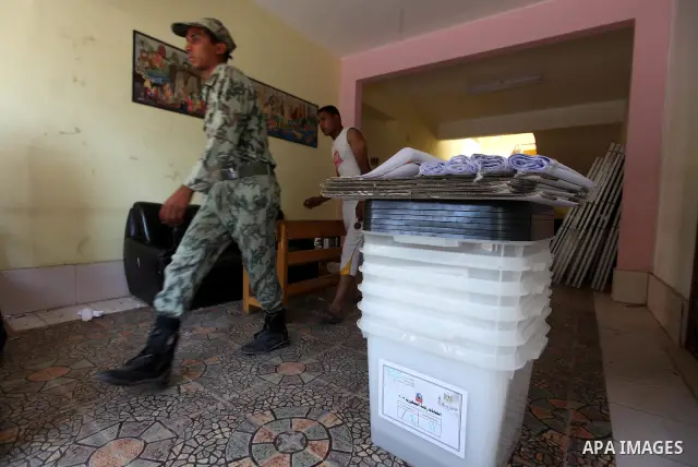 An Egyptian employee and soldier prepare a polling station on June 15, 2012 on the eve of Egypt's second round of presidential runoff elections. Egypt's transition to democracy was thrown into further disarray after its...