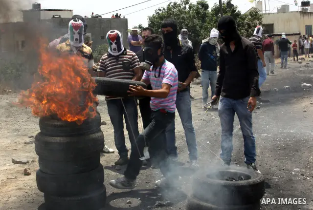 Palestinian protesters burn tires during clashes in the northern West Bank village of Kufr Qaddum, after the weekly protest against the expansion of the nearby Jewish settlement of Kdumim, on May 25, 2012. Photo by Nedal...