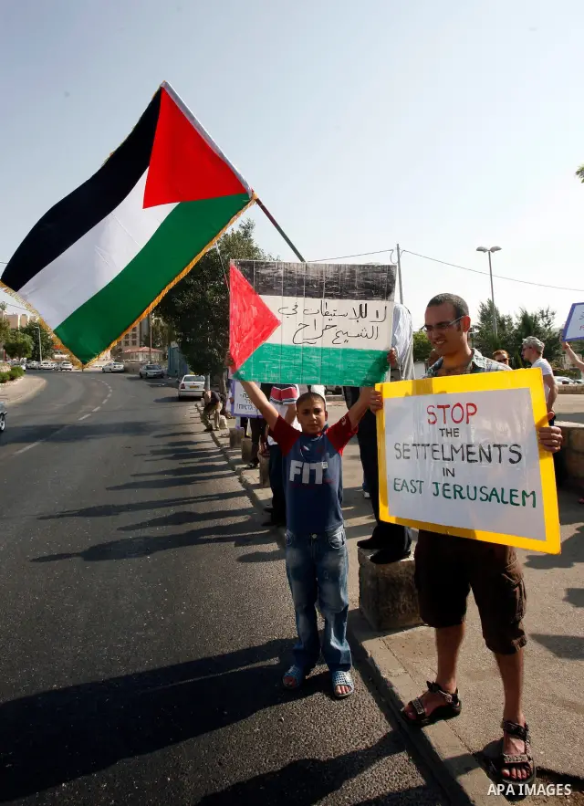 Palestinians hold national flags and banners during a protest against land confiscation in the neighborhood of Sheikh Jarrah in the east Jerusalem on 15 June, 2012. Photo by Mahfouz Abu Turk