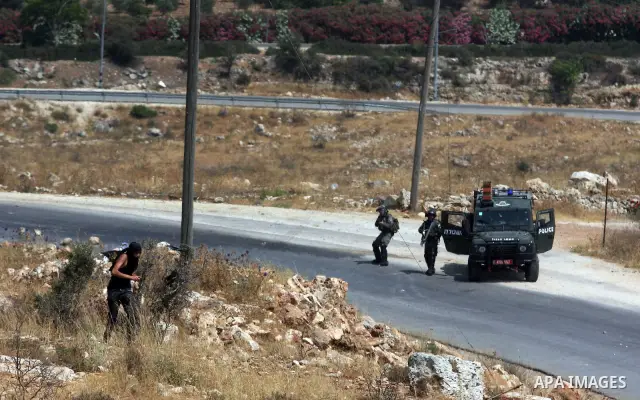 A Palestinian protester throws stones at Israeli soldiers during clashes in the West Bank village of Nabi Saleh, near Ramallah, on June 15, 2012, following a demonstration against the confiscation of Palestinian land to...