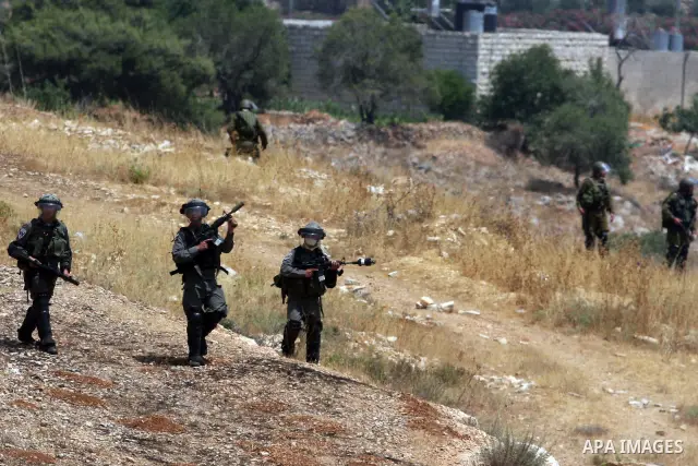 Israeli soldiers fire tear gas at Palestinians protester during clashes in the West Bank village of Nabi Saleh, near Ramallah, on June 15, 2012, following a demonstration against the confiscation of Palestinian land to e...
