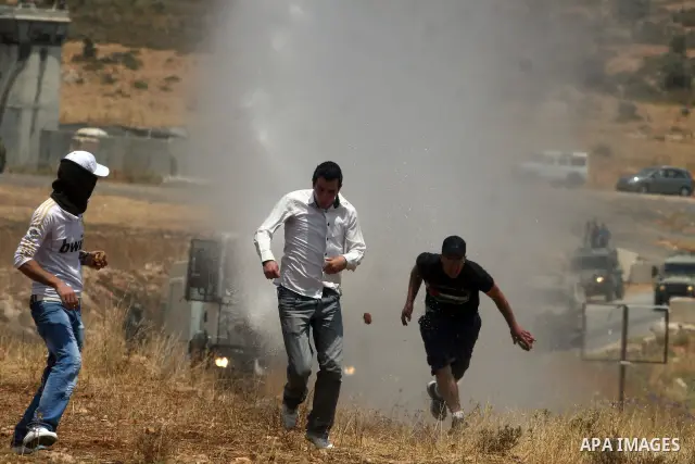 Israeli truck spray foul smelling water towards Palestinian protesters during clashes in the West Bank village of Nabi Saleh, near Ramallah, on June 15, 2012, following a demonstration against the confiscation of Palesti...