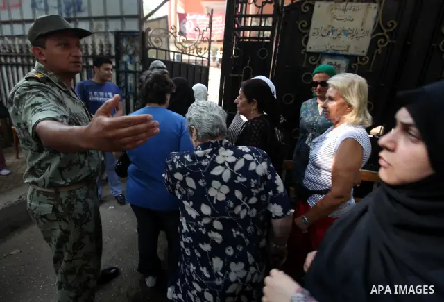Egyptian women wait outside a polling station in Cairo to cast their votes on June 16, 2012 in a divisive presidential runoff pitting ousted strongman Hosni Mubarak's last premier Ahmed Shafiq against Muslim Brotherhood...