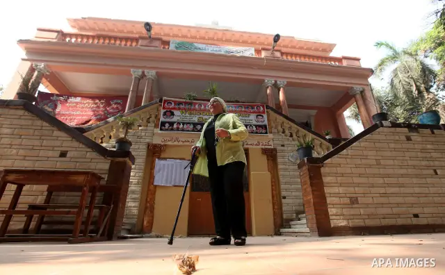 An Egyptian woman waits outside a polling station in Cairo to cast their votes on June 16, 2012 in a divisive presidential runoff pitting ousted strongman Hosni Mubarak's last premier Ahmed Shafiq against Muslim Brotherh...
