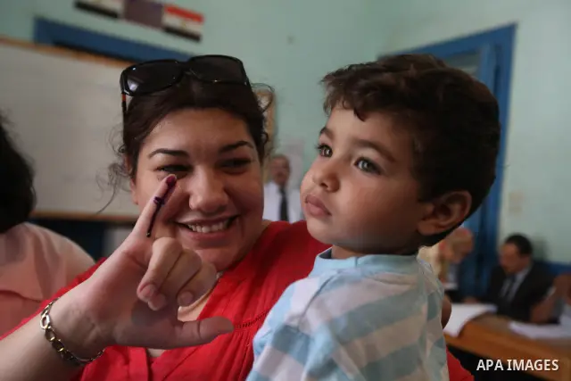 An Egyptian woman shows her ink-stained finger after casting her vote at a polling station in Cairo on June 16, 2012 in a divisive presidential runoff pitting ousted strongman Hosni Mubarak's last premier Ahmed Shafiq ag...