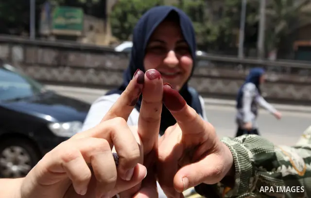 Egyptian women show her ink-stained finger after casting her vote at a polling station in Cairo on June 16, 2012 in a divisive presidential runoff pitting ousted strongman Hosni Mubarak's last premier Ahmed Shafiq agains...