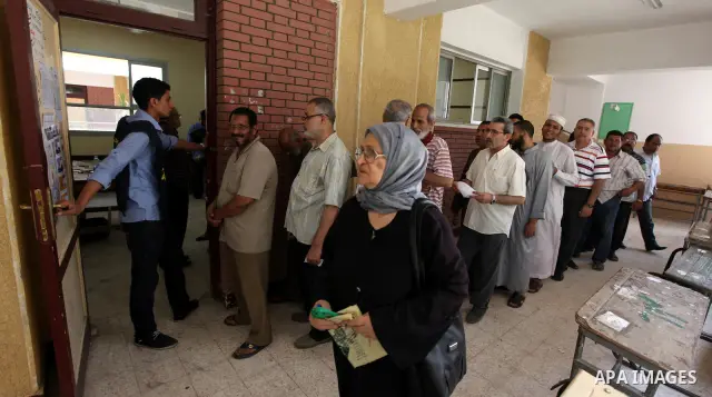 Egyptians queue outside a polling station in Cairo on June 16, 2012 to vote in a divisive presidential runoff pitting ousted strongman Hosni Mubarak's last premier Ahmed Shafiq against Muslim Brotherhood candidate Mohamm...