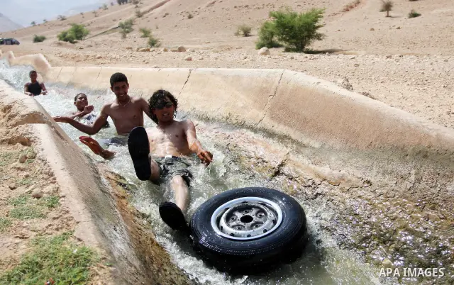 Palestinians cool off in the water of a natural spring known as Ein al-Auja, near the West Bank city of Jericho June 16, 2012. Photo by Issam Rimawi
