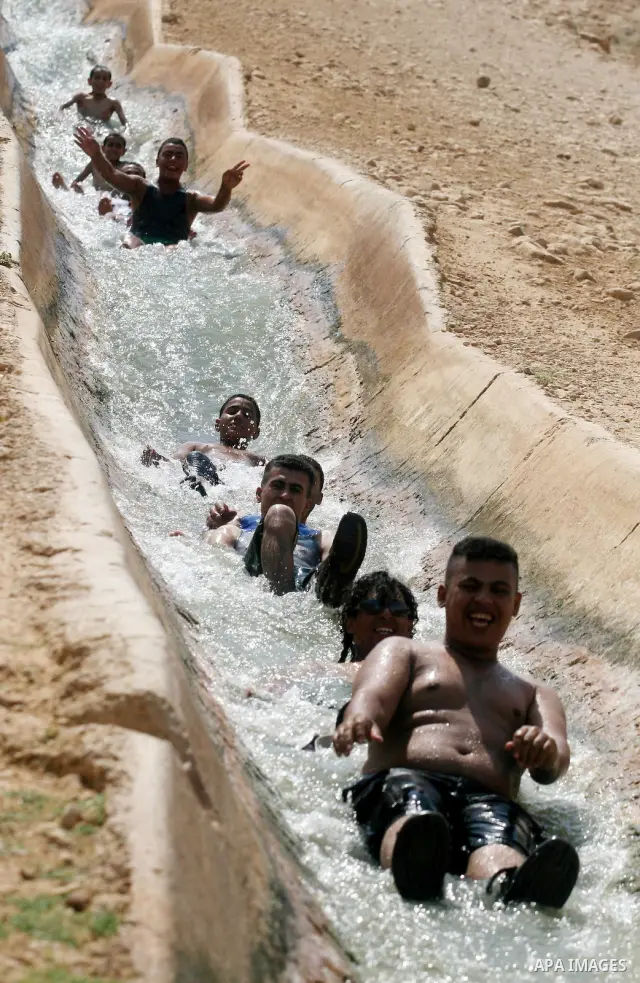 Palestinians cool off in the water of a natural spring known as Ein al-Auja, near the West Bank city of Jericho June 16, 2012. Photo by Issam Rimawi