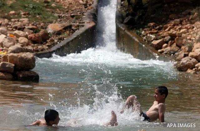 Palestinians cool off in the water of a natural spring known as Ein al-Auja, near the West Bank city of Jericho June 16, 2012. Photo by Issam Rimawi
