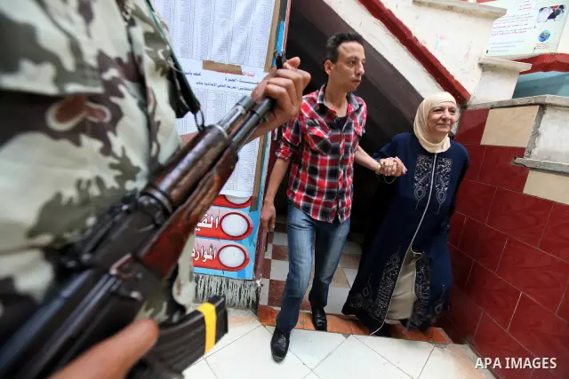 An Egyptian woman exits a polling station in Cairo after cast their votes on June 17, 2012 in a divisive presidential runoff pitting ousted strongman Hosni Mubarak's last premier Ahmed Shafiq against Muslim Brotherhood c...