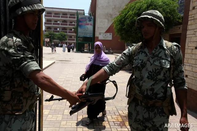 Egyptians solider stand guard outside a polling station in Cairo on June 17, 2012 in a divisive presidential runoff pitting ousted strongman Hosni Mubarak's last premier Ahmed Shafiq against Muslim Brotherhood candidate...