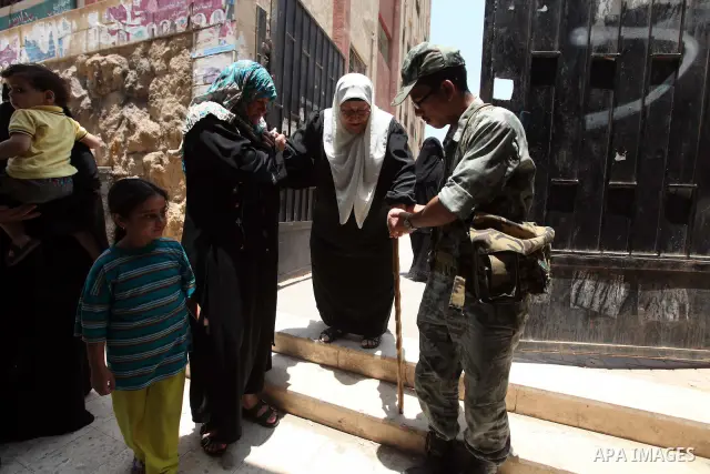 An Egyptian army soldier helps a woman while leaving the polling station after voting during the second day of a run-off presidential election, in Cairo, Egypt, 17 June 2012. Egyptians began to vote in the final day of t...