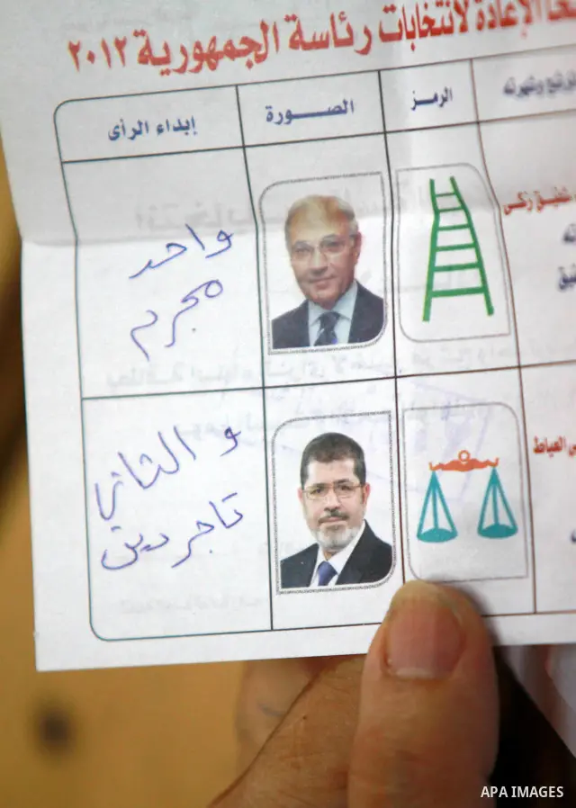 An electoral worker shows an invalid ballot, on which a voter has marked with multiple crosses and written "void" next to both candidates, after polls closed in Cairo June 17, 2012. Egyptians began an anxious wait for th...