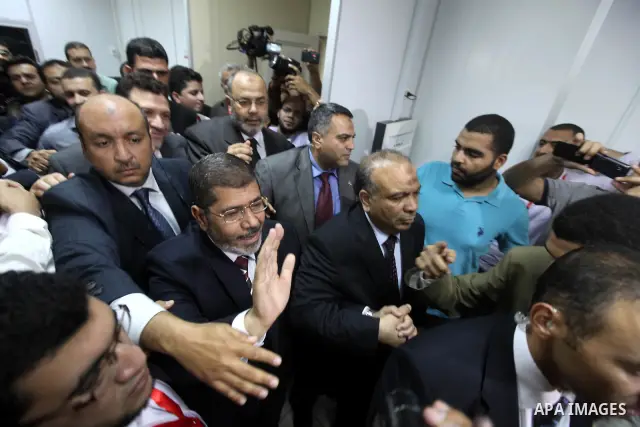 Egypt's Muslim Brotherhood candidate Mohammed Mursi waves amongst his supporters after the announcement of presidential election results at the electoral headquarters in Cairo on June 18, 2012. The campaign of Egyptian p...