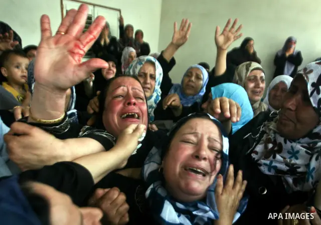 Relatives of Palestinian militant Ismail Odeh mourn during his funeral in Beit Hanun in the northern Gaza Strip on June 18, 2012. Odeh was one of two Palestinians killed in an Israeli strike on north Gaza in the morning,...
