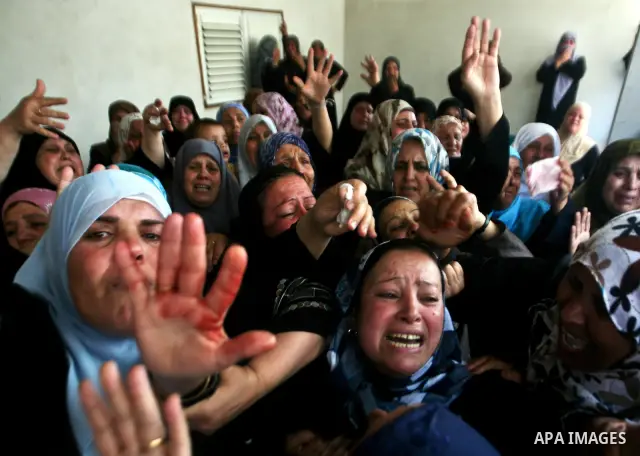 Relatives of Palestinian militant Ismail Odeh mourn during his funeral in Beit Hanun in the northern Gaza Strip on June 18, 2012. Odeh was one of two Palestinians killed in an Israeli strike on north Gaza in the morning,...