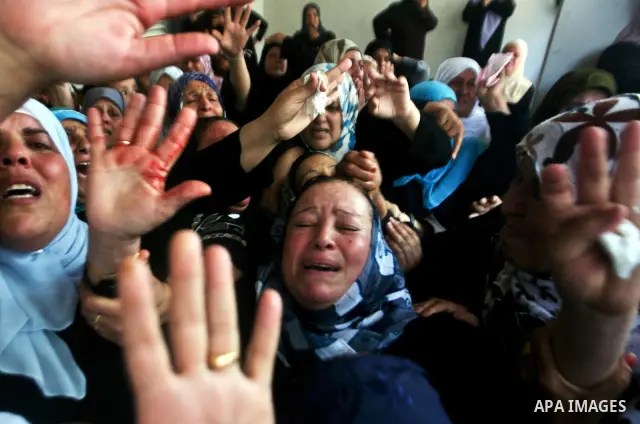 Relatives of Palestinian militant Ismail Odeh mourn during his funeral in Beit Hanun in the northern Gaza Strip on June 18, 2012. Odeh was one of two Palestinians killed in an Israeli strike on north Gaza in the morning,...