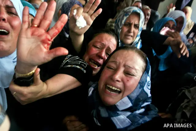 Relatives of Palestinian militant Ismail Odeh mourn during his funeral in Beit Hanun in the northern Gaza Strip on June 18, 2012. Odeh was one of two Palestinians killed in an Israeli strike on north Gaza in the morning,...