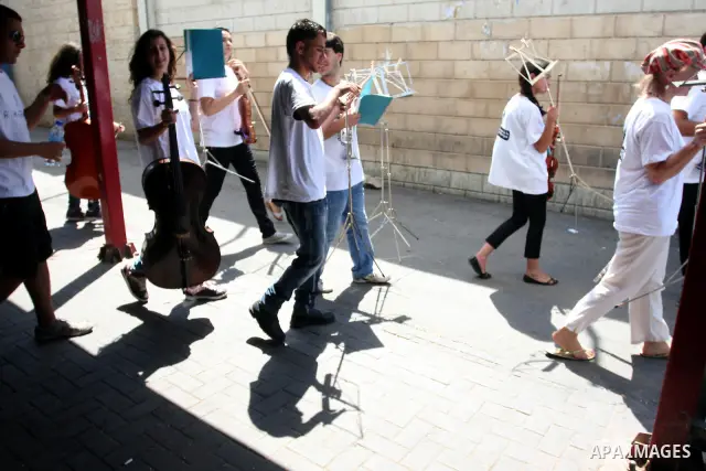 Palestinian, Israeli and foreign musicians band during their presentation at the Israeli military Qalandia checkpoint between Jerusalem city and Ramallah in West Bank on 18 June 2012. Photo by Issam Rimawi