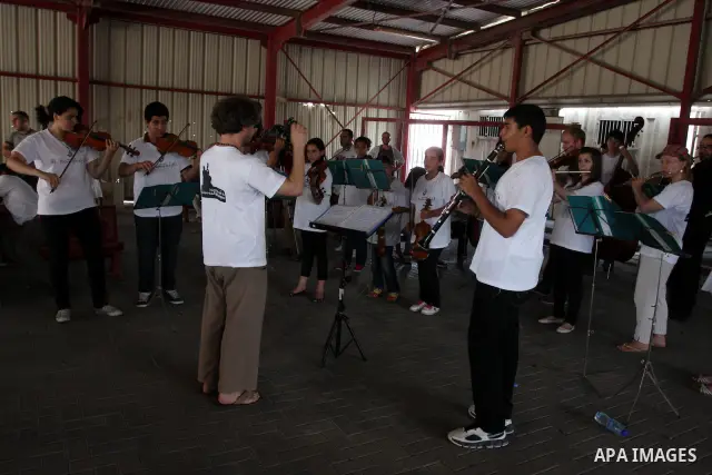 Palestinian, Israeli and foreign musicians band during their presentation at the Israeli military Qalandia checkpoint between Jerusalem city and Ramallah in West Bank on 18 June 2012. Photo by Issam Rimawi