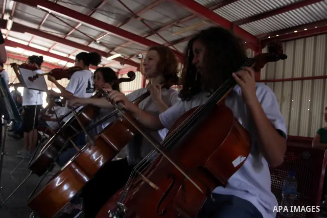 Palestinian, Israeli and foreign musicians band during their presentation at the Israeli military Qalandia checkpoint between Jerusalem city and Ramallah in West Bank on 18 June 2012. Photo by Issam Rimawi
