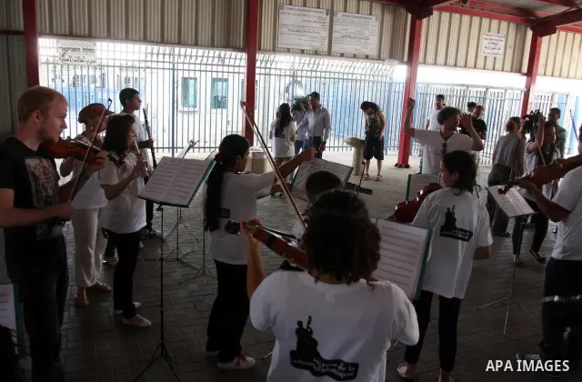 Palestinian, Israeli and foreign musicians band during their presentation at the Israeli military Qalandia checkpoint between Jerusalem city and Ramallah in West Bank on 18 June 2012. Photo by Issam Rimawi