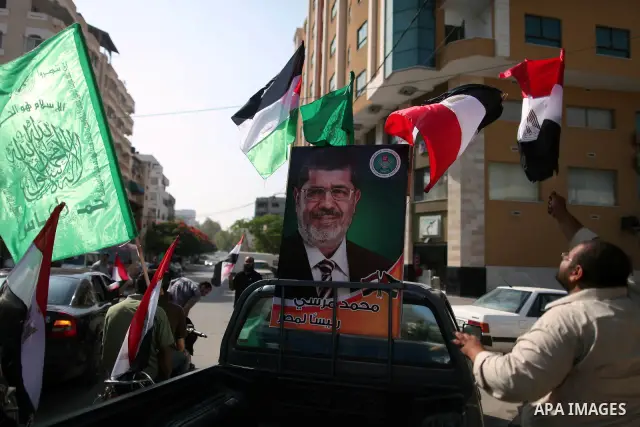 Palestinian Hamas supporters hold up Egyptian flags and the poster of the Muslim Brotherhood's presidential candidate Mohammed Morsi as they celebrate in the streets of Gaza City, 18 June 2012. Egypt's Muslim Brotherhood...
