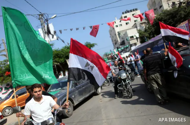 Palestinian Hamas supporters hold up Egyptian flags and the poster of the Muslim Brotherhood's presidential candidate Mohammed Morsi as they celebrate in the streets of Gaza City, 18 June 2012. Egypt's Muslim Brotherhood...