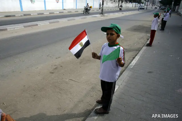 Palestinian boys supporter hold up Egyptian flags as they celebrate in Rafah, in the southern Gaza Strip, 19 June 2012. Egypt's Muslim Brotherhood claimed on 18 June 2012 victory in Egypt's first presidential election si...