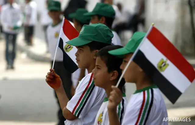 Palestinian boys supporter hold up Egyptian flags as they celebrate in Rafah, in the southern Gaza Strip, 19 June 2012. Egypt's Muslim Brotherhood claimed on 18 June 2012 victory in Egypt's first presidential election si...