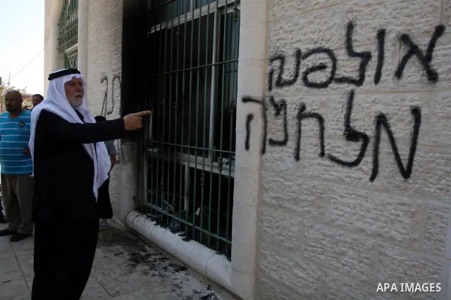 Palestinians look into a damaged mosque in West Bank village of Jaba near Ramallah June 19, 2012. The mosque in the occupied West Bank was vandalised and set on fire early on Tuesday, in an attack Palestinians blamed on...