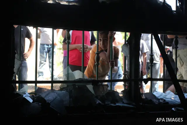 Palestinians look into a damaged mosque in West Bank village of Jaba near Ramallah June 19, 2012. The mosque in the occupied West Bank was vandalised and set on fire early on Tuesday, in an attack Palestinians blamed on...