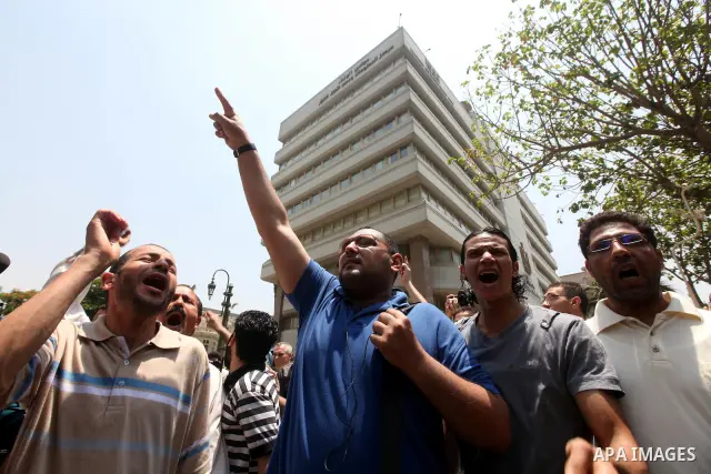 Egyptians protestors chat anti-Supreme Council for the Armed Forces (SCAF) slogans outside the parliament in Cairo, on June 19, 2012, after the Supreme Council of the Armed Forces (SCAF) issued a constitutional declarati...