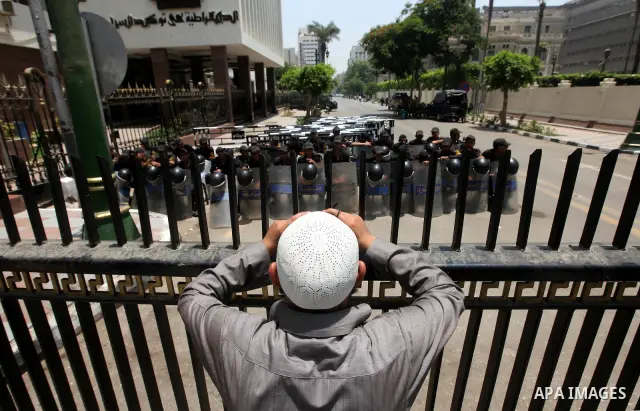 An Egyptian man stands in front of riot police blocking the access to the street of the parliament in Cairo, Egypt, 09 June 2012. A new constitutional document issued by the Supreme Council of the Armed Forces (SCAF), gr...