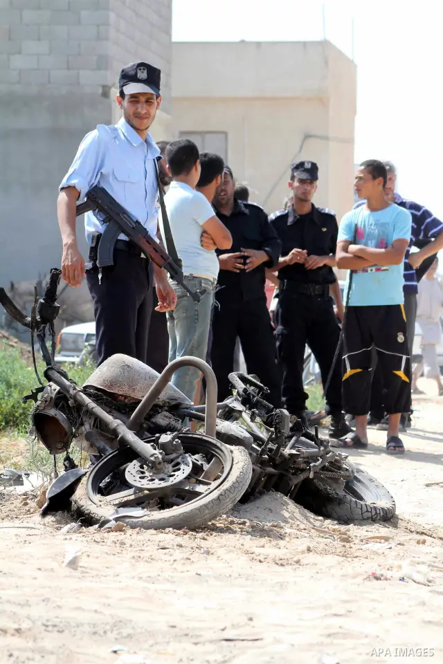 A Hamas policeman stands near a motorcycle that was hit in an Israeli air strike in Dir al-Balah in the central Gaza Strip June 19, 2012. An Israeli army statement said the Israeli air force targeted Palestinian militant...