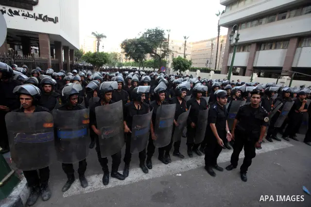 Egyptian riot police stand guard, during a protest against the military council at the gates of Egypt's parliament in Cairo June 19, 2012. Egypt's Muslim Brotherhood declared on Tuesday it did not want a confrontation wi...