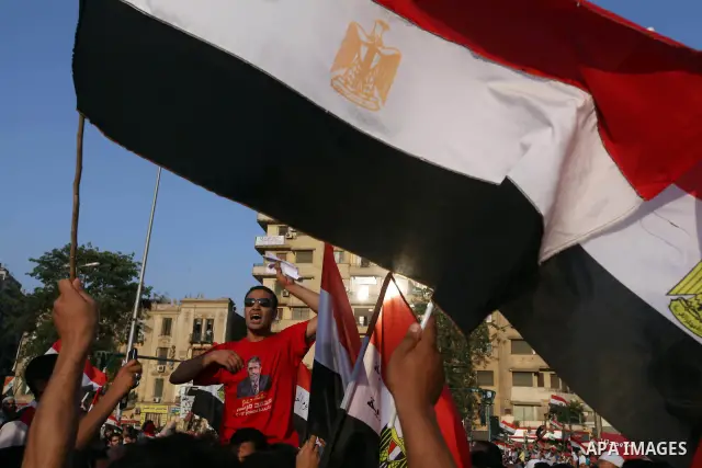 Egyptian supporters of Muslim Brotherhood presidential candidate Mohammed Mursi wave their national flag as they gather in Cairo's Tahrir Square on June 19, 2012 to protest against the ruling military's bid to grab new p...