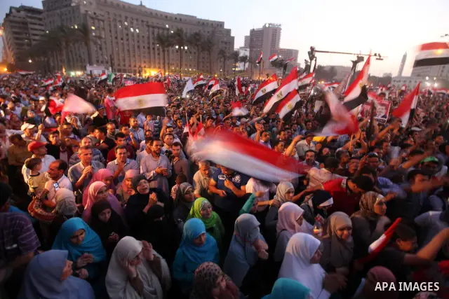Egyptian supporters of Muslim Brotherhood presidential candidate Mohammed Mursi wave their national flag as they gather in Cairo's Tahrir Square on June 19, 2012 to protest against the ruling military's bid to grab new p...
