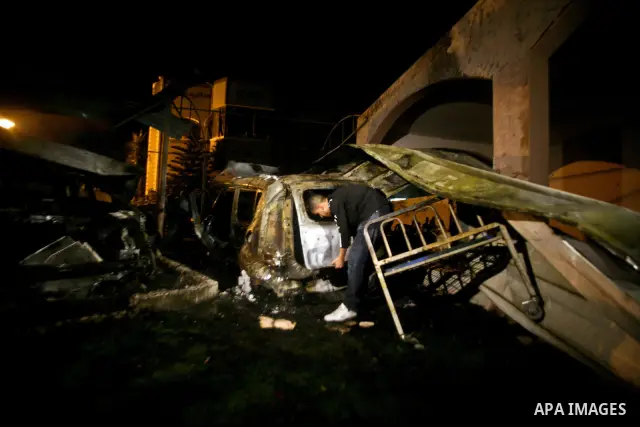 A Palestinian inspects a destroyed car after it was hit in an Israeli air strike in Al Zaiton area in the east of Gaza city on, 20 June 2012. Photo by Ali Jadallah