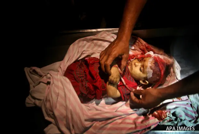 A Palestinian man looks at the body of two-year-old girl, Hadeel al-Hadad, at a hospital in Gaza City June 19, 2012. Israel killed two Palestinians in air strikes and Hamas fired its first cross-border rocket barrages in...
