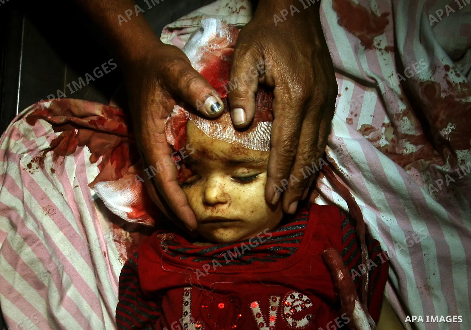 A Palestinian man looks at the body of two-year-old girl, Hadeel al-Hadad, at a hospital in Gaza City June 19, 2012. Israel killed two Palestinians in air strikes and Hamas fired its first cross-border rocket barrages in...
