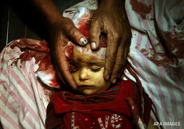 A Palestinian man looks at the body of two-year-old girl, Hadeel al-Hadad, at a hospital in Gaza City June 19, 2012. Israel killed two Palestinians in air strikes and Hamas fired its first cross-border rocket barrages in...