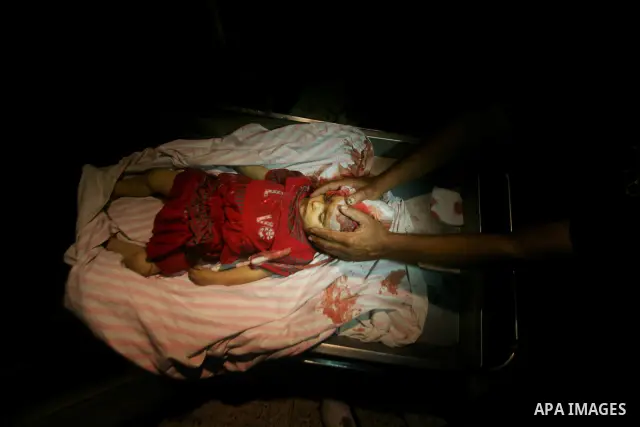 A Palestinian man looks at the body of two-year-old girl, Hadeel al-Hadad, at a hospital in Gaza City June 19, 2012. Israel killed two Palestinians in air strikes and Hamas fired its first cross-border rocket barrages in...
