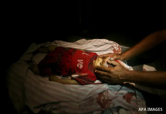 A Palestinian man looks at the body of two-year-old girl, Hadeel al-Hadad, at a hospital in Gaza City June 19, 2012. Israel killed two Palestinians in air strikes and Hamas fired its first cross-border rocket barrages in...