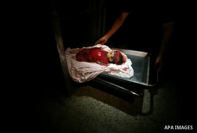 A Palestinian man looks at the body of two-year-old girl, Hadeel al-Hadad, at a hospital in Gaza City June 19, 2012. Israel killed two Palestinians in air strikes and Hamas fired its first cross-border rocket barrages in...